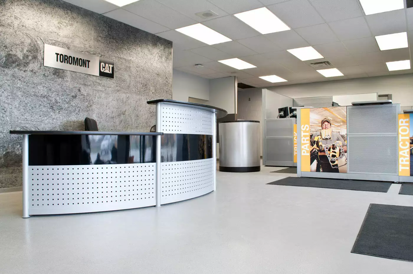 Modern office lobby with two curved reception desks, featuring branded banners for toromont cat, and a clean, professional design.