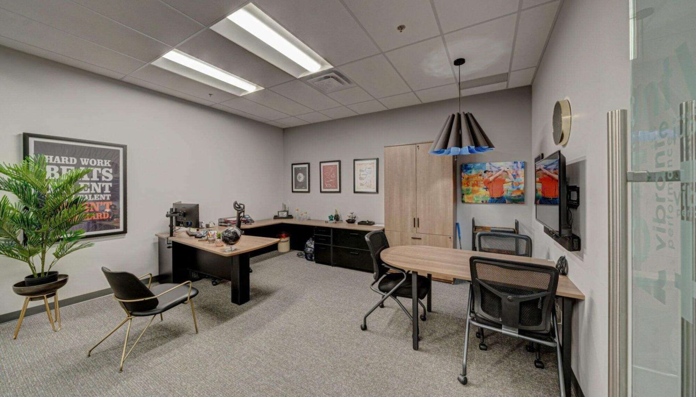 An image of a private office with desks, plant, and artwork